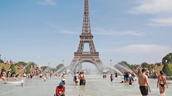 People bathe in the Trocadero Fountain in front of the Eiffel Tower in Paris during a heatwave on June 28, 2019. - The temperature in France on June 28 surpassed 45 degrees Celsius (113 degrees Fahrenheit) for the first time as Europe wilted in a major heatwave, state weather forecaster Meteo-France said. (Photo by Zakaria ABDELKAFI)