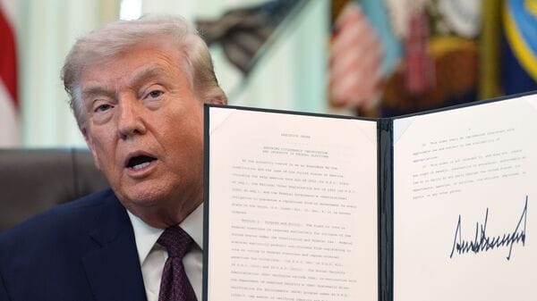 President Donald Trump holds a signed executive order in the Oval Office of the White House Tuesday, March 31, 2026, in Washington. AP/PTI(AP04_01_2026_000012A)