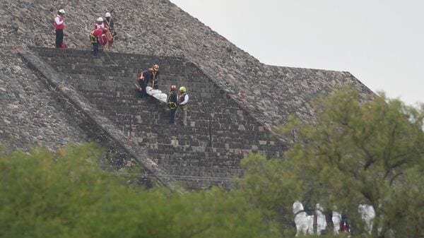 Forensic workers carry the body of a victim down a pyramid after authorities said a gunman opened fire, in Teotihuacan, Mexico, Monday, April 20, 2026. AP/PTI