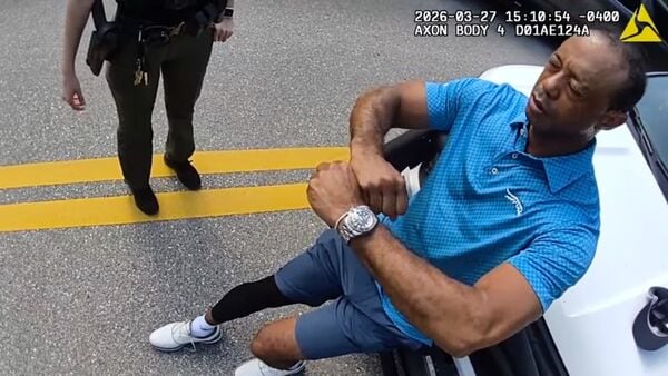 In this image taken from police body camera video released by the Martin County, Fla., Sheriff's Office, golfer Tiger Woods performs a field sobriety test for sheriff's deputies following a car crash in Jupiter Island, Fla., Friday, March 27, 2026. (Martin County Sheriff's Office via AP)