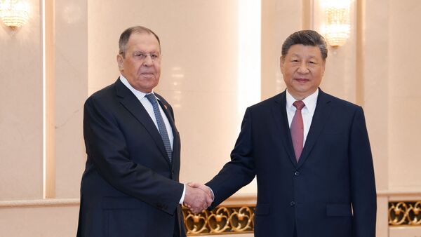 This handout picture provided by the Russian Foreign Ministry on 15 April 2026 shows Russia's Foreign Minister Sergei Lavrov (L) shaking hands with China's President Xi Jinping in Beijing.
