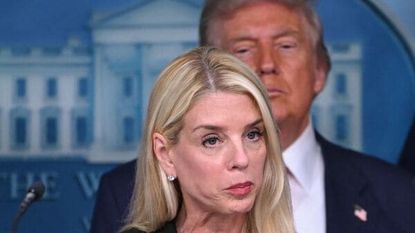 (FILES) US President Donald Trump (R) looks on as Attorney General Pam Bondi speaks during a news conference to discuss crime in Washington, DC, in the Brady Press Briefing Room at the White House in Washington, DC, on August 11, 2025. (Photo by ANDREW CABALLERO-REYNOLDS / AFP)