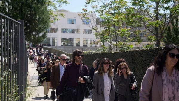 People leave a courthouse after a gunman opened fire leaving several people wounded in Athens, Tuesday.