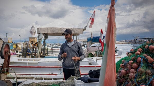Mohamed Khalil, a 47-year-old fisherman, repairs his fishing net as he stands in his boat, amid escalating hostilities between Israel and Hezbollah, as the U.S.-Israeli conflict with Iran continues, at a port in Tyre, Lebanon, April 7, 2026. REUTERS/Adnan Abidi
