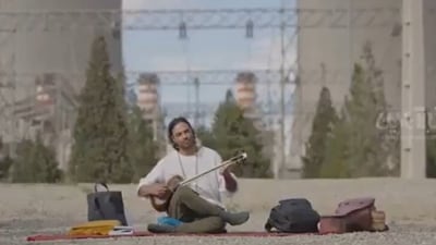 The Iranian musician Ghamsari plays in front of a power plant, civilian infrastructure whose destruction is threatened by Trump. (X/@IraninBerlin)