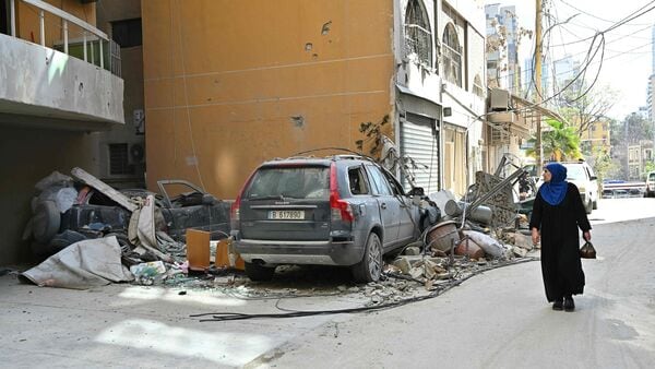 A woman walks past the site of an Israeli airstrike in the Basta neighbourhood of Beirut on 9 April.
