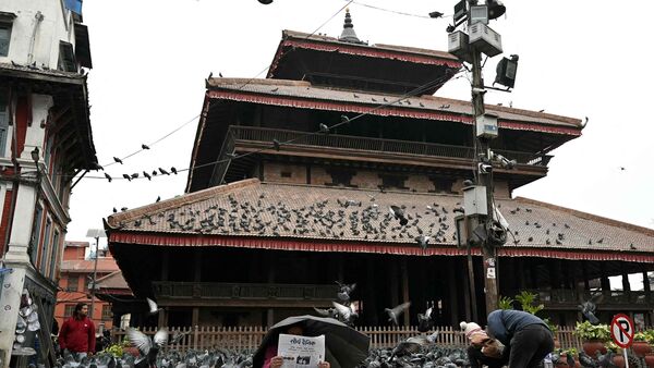 A vendor reads a newspaper while waiting for customers in Kathmandu on March 6, 2026 a day after Nepal's Parliamentary election.