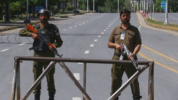 Police officers stand guard at a checkpoint on a road leading to Serena Hotel ahead of second round of the U.S. Iran officials talks, in Islamabad, Sunday, April 19, 2026. (AP Photo/Ehsan Shahzad)