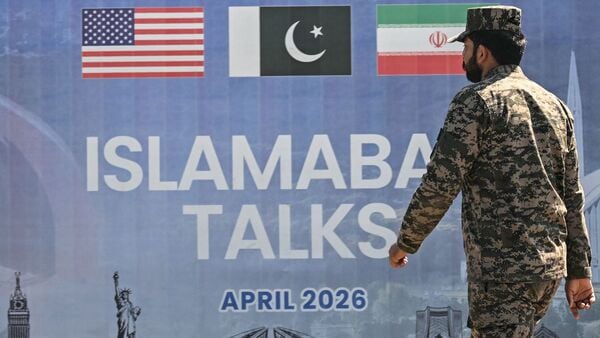 A Pakistani Ranger walks past a billboard for the US-Iran peace talks in Islamabad on April 12, 2026. Iran and the United States failed to reach an agreement to end the war in the Middle East, US Vice President JD Vance said on April 12 after marathon talks in Islamabad, adding that he was leaving negotiations after giving Tehran the 'final and best offer'