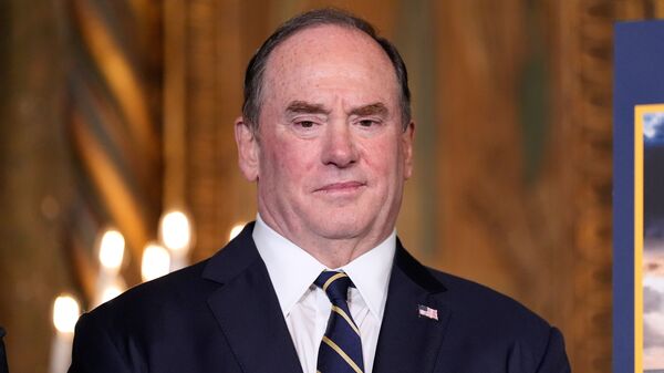 FILE - Secretary of the Navy John Phelan listens as President Donald Trump speaks at his Mar-a-Lago club, Dec. 22, 2025, in Palm Beach, Fla. (AP Photo/Alex Brandon, file)