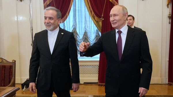 Russian President Vladimir Putin, right, and Iranian Foreign Minister Abbas Araghchi walk to attend the talks at the Boris Yeltsin Presidential Library, in St. Petersburg, Russia, Monday, April 27, 2026. (AP Photo/Dmitri Lovetsky, Pool)