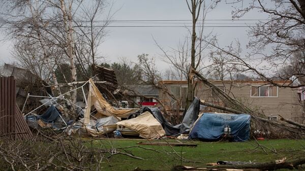 Debris and fallen tree limbs cover the ground after a severe storm that tore through the Upper Midwest on Friday, April 17, 2026, in Rochester, Minn.   (Hollie Bennett Piotrowicz via AP)