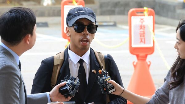 US YouTuber Johnny Somali speaks to reporters as he arrives at a court to attend his trial over charges including obstruction of business and violations of minor public order laws, at the Seoul Western District Court in Seoul on April 15, 2026.