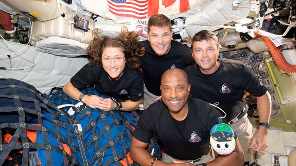 The NASA Artemis II crew, Mission Specialist Christina Koch, Mission Specialist Jeremy Hansen, Commander Reid Wiseman, and Pilot Victor Glover, pose for a group photo inside the Orion spacecraft on their way home following a flyby of the far side of the Moon on April 6, 2026.