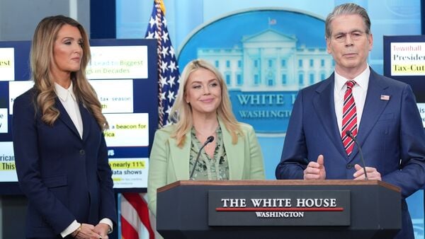White House press secretary Karoline Leavitt and Small Business Administration administrator Kelly Loeffler listen as Treasury Secretary Scott Bessent speaks with reporters in the James Brady Press Briefing Room at the White House, Wednesday, April 15, 2026, in Washington. (AP Photo/Alex Brandon)