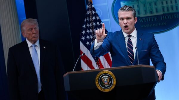 President Donald Trump watches as Defense Secretary Pete Hegseth speaks with reporters in the James Brady Press Briefing Room at the White House, Monday, April 6, 2026, in Washington DC