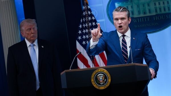President Donald Trump watches as Defense Secretary Pete Hegseth