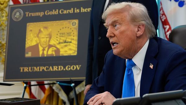 FILE - A poster showing the Trump Gold Card is seen as President Donald Trump signs executive orders in the Oval Office of the White House