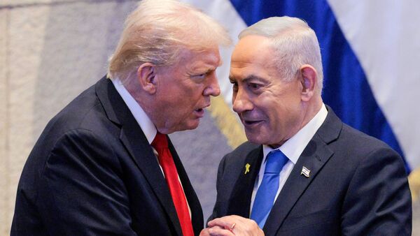 US President Donald Trump (L) holds hands and speaks with Israeli Prime Minister Benjamin Netanyahu at the Israeli parliament, the Knesset, in Jerusalem on October 13, 2025.