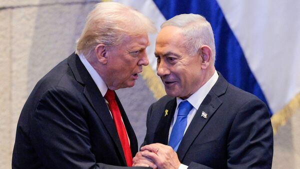 US President Donald Trump (L) holds hands and speaks with Israeli Prime Minister Benjamin Netanyahu at the Israeli parliament, the Knesset, in Jerusalem on October 13, 2025.