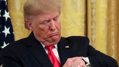 President Donald Trump checks his watch during an event to celebrate federal judicial confirmations in the East Room (REUTERS)