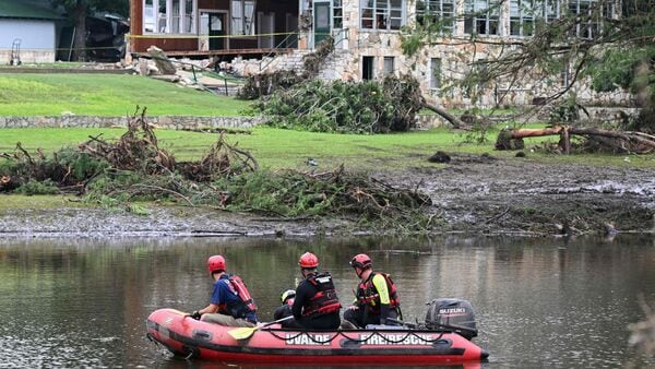 A search and rescue team looks for people along the Guadalupe River near a damaged building at Camp Mystic in Hunt, Texas, on July 7, 2025,