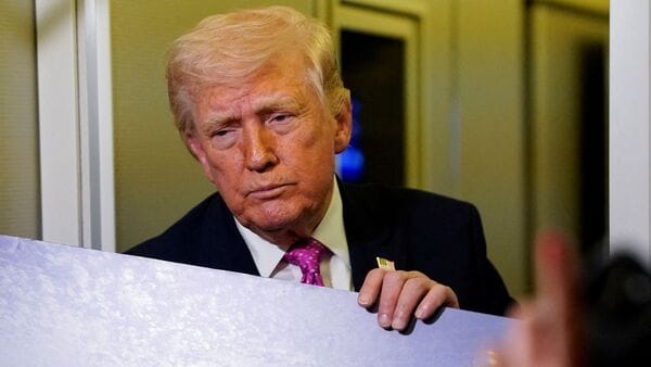 FILE PHOTO: A member of the media raises her hand for a question as U.S. President Donald Trump talks while holding up renderings of the planned White House ballroom, aboard Air Force One en route to Joint Base Andrews, Maryland, U.S., March 29, 2026. REUTERS/Elizabeth Frantz/File Photo