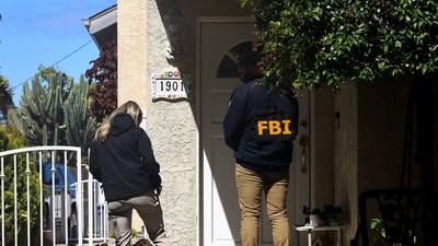 An FBI member stands outside a building next to the house associated with Cole Tomas Allen, the suspect in the shooting incident in Washington at the annual White House Correspondents' Association dinner, in Torrance, California, U.S. (REUTERS)
