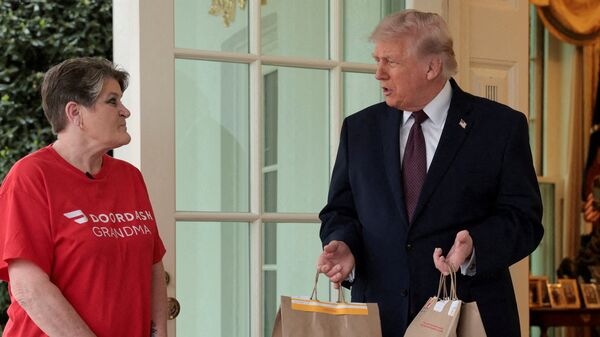 U.S. President Donald Trump holds McDonald's bags outside the Oval Office at the White House, in Washington, D.C., U.S., April 13, 2026. REUTERS/Jonathan Ernst/File Photo