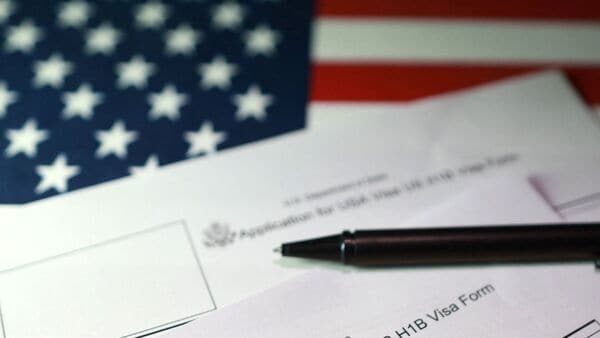 A US flag and US Visa application forms are seen in this illustration taken on 22 September 2025. (Representative image)