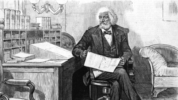 American orator, editor, author, abolitionist and former slave Frederick Douglass (1818 - 1895) edits a journal at his desk, late 1870s.