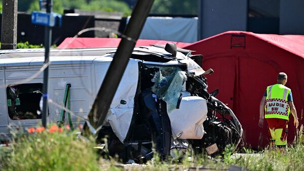 This photograph shows a damaged train car at the site of an accident after a train crashed into a school bus, at the railway crossing Vierhuizen in Buggenhout on May 26, 2026.