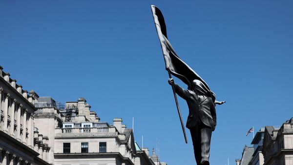 A statue, depicting a figure carrying a flag covering their face and stepping off a plinth, by British street artist Banksy, stands in London, on 1 May 2026.
