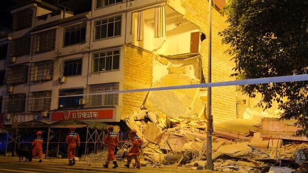 Rescue workers walk past a damaged building following an earthquake at Taiyang village in Liuzhou, Guangxi Zhuang Autonomous Region, China May 18, 2026. cnsphoto via REUTERS   ATTENTION EDITORS - THIS IMAGE WAS PROVIDED BY A THIRD PARTY. CHINA OUT. NO COMMERCIAL OR EDITORIAL SALES IN CHINA
