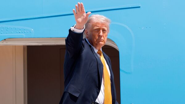 President Donald Trump waves from the stairs of Air Force One as he boards upon his arrival at Joint Base Andrews for a trip to China to meet President Xi Jinping
