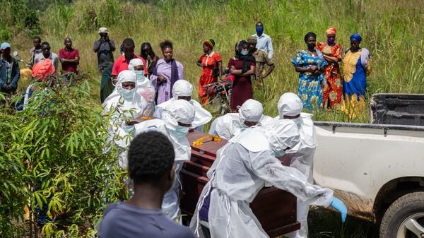 Red Cross workers prepare a coffin containing the body of the Ebola victim for burial at the Rwampara Cemetery, in Bunia, Congo, Saturday, May 23