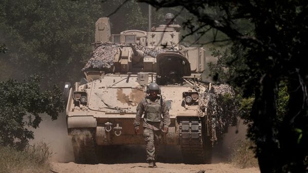FILE PHOTO: A U.S. soldier walks in front of an armoured vehicle during 'Balkan Sentinel - 25' military drill, an exercise involving personnel and equipment from the Bulgarian Land Forces and Air Force, formations from the NATO Multinational Battle Group with Italy, and a mechanized platoon from the Romanian Land Forces, in Koren, Bulgaria, June 9, 2025. REUTERS/Stoyan Nenov/File Photo