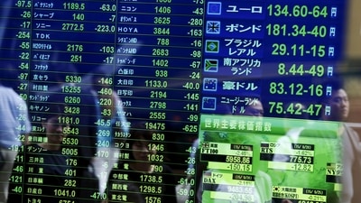 assersby are reflected on a screen displaying  stock quotation, the stock market indices of various countries (REUTERS)