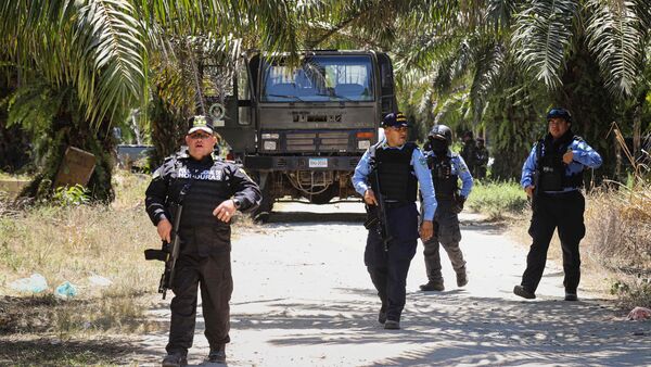 Police officers patrol near the site of a massacre in Trujillo, Honduras.