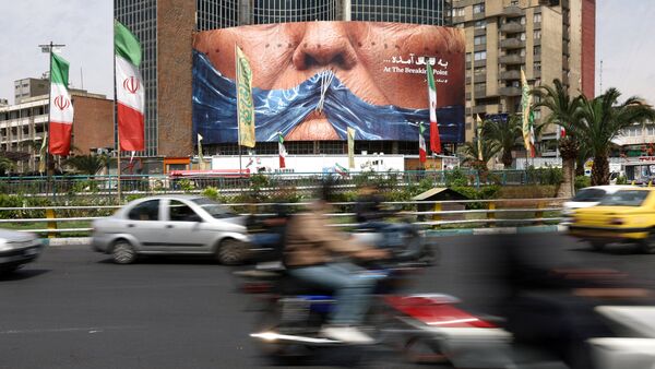 People drive past an anti-US billboard depicting President Donald Trump and the Strait of Hormuz, in Tehran, Iran, May 2, 2026.