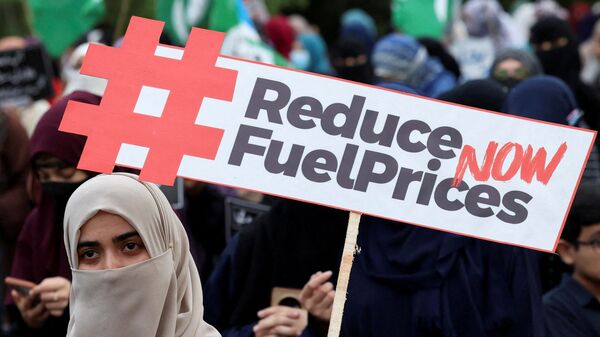 File photo for representative purposes only: A woman holds a placard during a protest, calling the government to reduce the fuel prices in Islamabad, Pakistan.