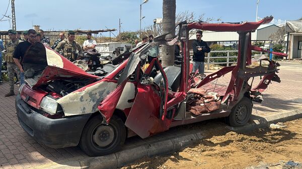 People gather at the site of an Israeli strike near Sidon, Lebanon.