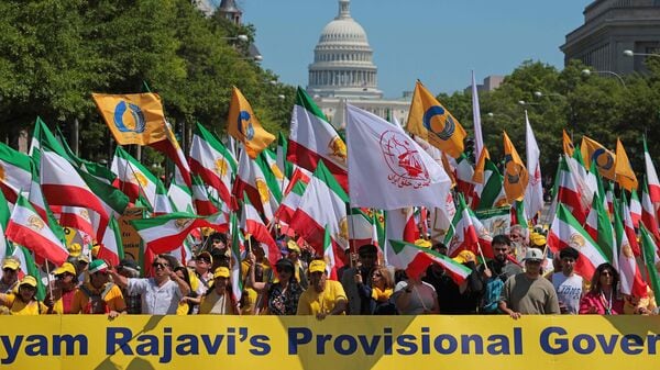 Supporters of Iranian dissident politician Maryam Rajavi wave pre-revolution Iranian flags as they march along Pennsylvania Avenue while demonstrating for the overthrow of the Islamic revolutionary government on May 16, 2026 in Washington, DC. Chip Somodevilla/Getty Images/AFP