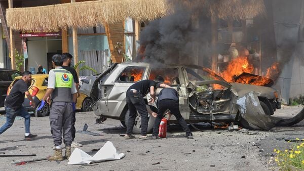 People attempt to extinguish a burning vehicle after an Israeli airstrike hit a car in the coastal town of Barja, south of Beirut, Lebanon, Wednesday, May 13, 2026.