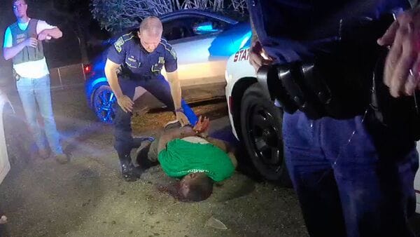 This image from video from Louisiana state trooper Lt. John Clary's body-worn camera shows trooper Kory York standing over Ronald Greene on his stomach on May 10, 2019, outside of Monroe, La. (Lt. John Clary/Louisiana State Police via AP, File)
