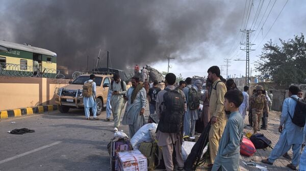 Volunteers look for victims from an overturned train coach on a railway track as survivors wait for transport at the site of bomb explosion, in Quetta, Pakistan, Sunday, May 24, 2026. (AP Photo/Arshad Butt)