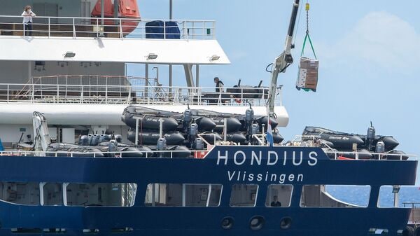 The Dutch flagged hantavirus-stricken cruise ship MV Hondius receives provisions from a boat in the port of Granadilla de Abona on the island of Tenerife in Spain's Canary Islands on May 11, 2026. (Photo by JORGE GUERRERO / AFP)
