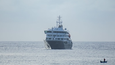 Hantavirus outbreak: A fisherman sails past the cruise ship MV Hondius stationary off the port of Praia, the capital of Cape Verde, on May 5, 2026. (Photo by AFP) (AFP)