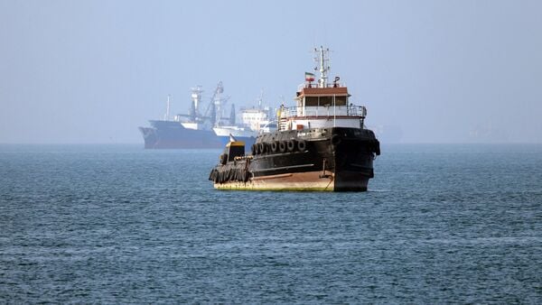 Iran-flagged tugboat Basim sails near a ship anchored in the Strait of Hormuz off Bandar Abbas in southern Iran