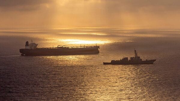 This US Navy handout photo released on May 8, 2026 by US Central Command Public Affairs, shows the Arleigh Burke-class guided-missile destroyer USS Rafael Peralta (DDG 115) implementing a maritime blockade against the Iran-flagged crude oil tanker vessel Herby while the latter was attempting to sail toward an Iranian port, on April 24, 2026. The war launched by the US and Israel in late February saw Iran respond with attacks across the Middle East and maintain a stranglehold on the Strait of Hormuz, choking off major flows of oil, gas, and fertilizer to the world economy, while the US has imposed a counter-blockade on Iranian ports. (Photo by US NAVY / AFP)